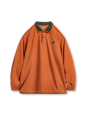 オレンジの長袖ニットポロ、重ね襟と裾のグリーン切替、胸元に幾何学刺繍と立体装飾、ルーズシルエット