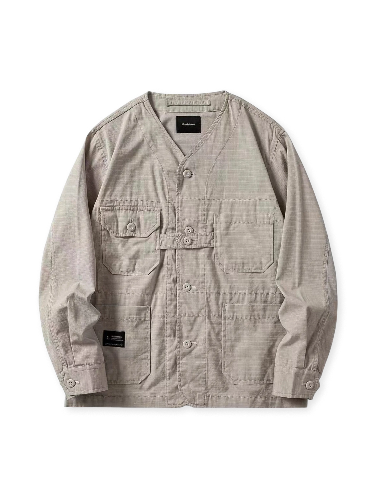 ノーカラー仕様で多機能ポケットを備えた、防泼水・速乾・抗シワ機能付きの軽量ミリタリージャケット。ルーズシルエットと丸みのある裾が特徴。