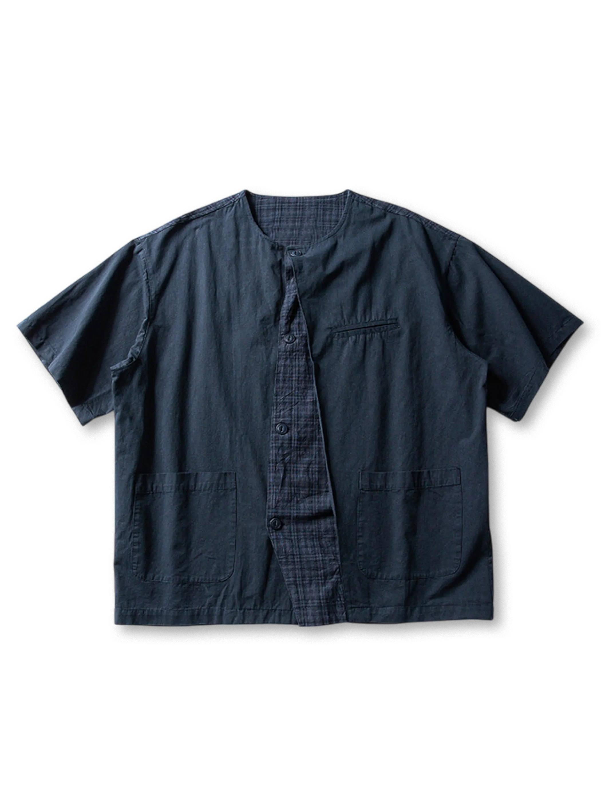 チェックパネルと同色ポケットを配したノーカラーデザインの薄手コットンレイヤードシャツ