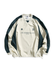 Vネックと対比カラーのブロックパネルを持つスポーティなスウェット。ドローコード裾とゴム袖口、プリント刺繍が特徴