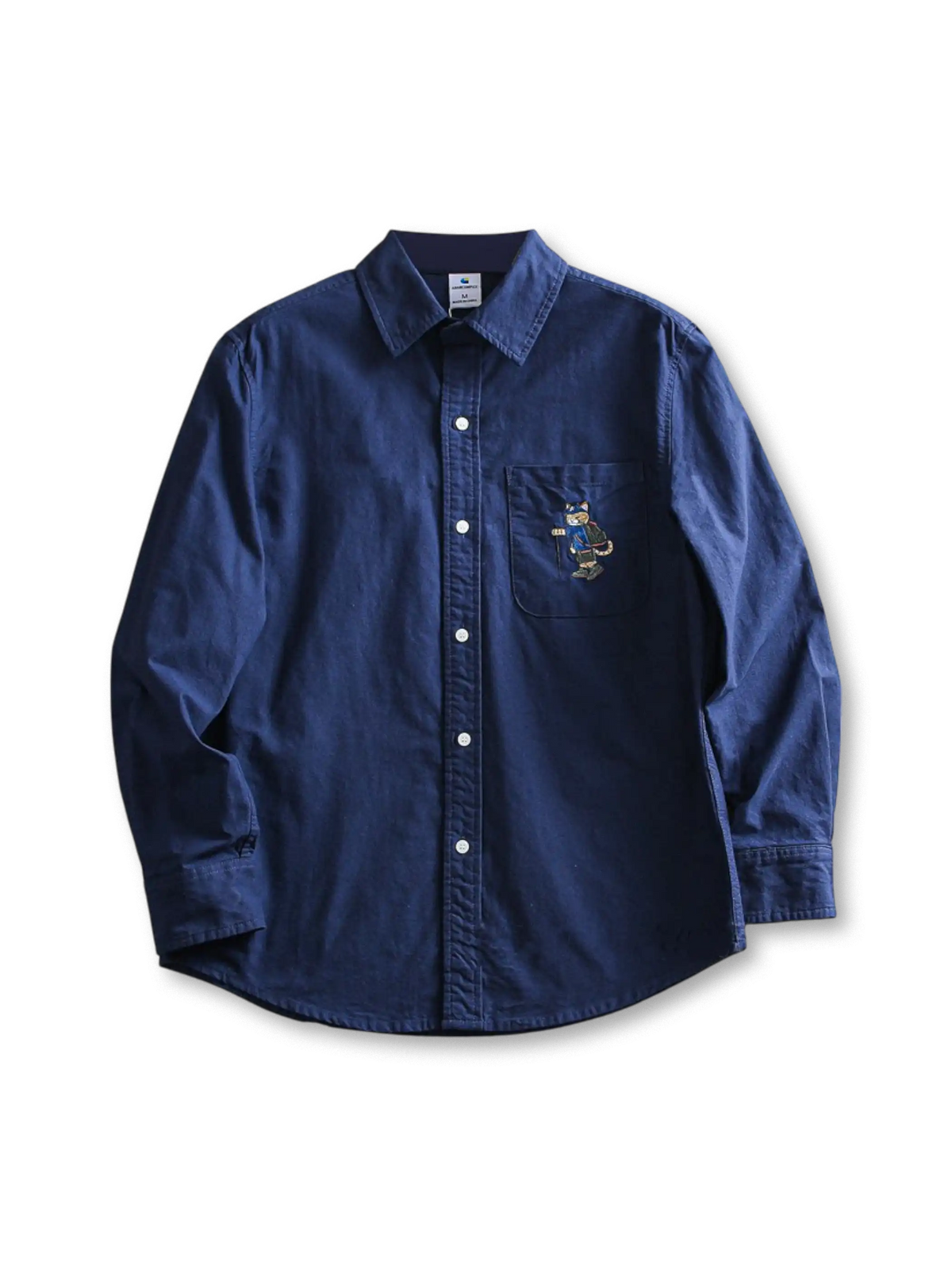 水洗い加工のコットンオックスフォード生地と猫刺繍が特徴のゆったりシルエットシャツ。多用途に活躍。