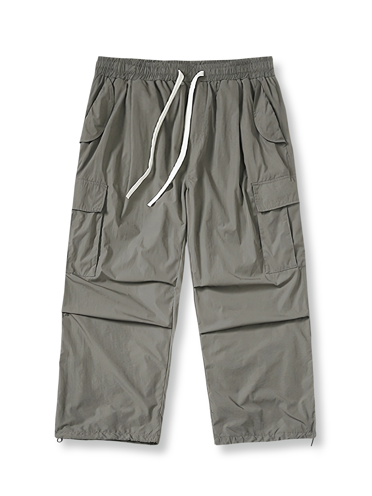 多ポケットとドローストリングウエストを備えた軽量ポリエステル製パラシュートパンツ。ワイドシルエットで動きやすく、ヴィンテージ感あるデザイン。