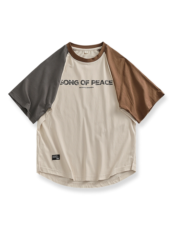 パッチワークとラグランスリーブ、カーブヘムが特徴の「SONG OF PEACE」プリント入りコットンTシャツ