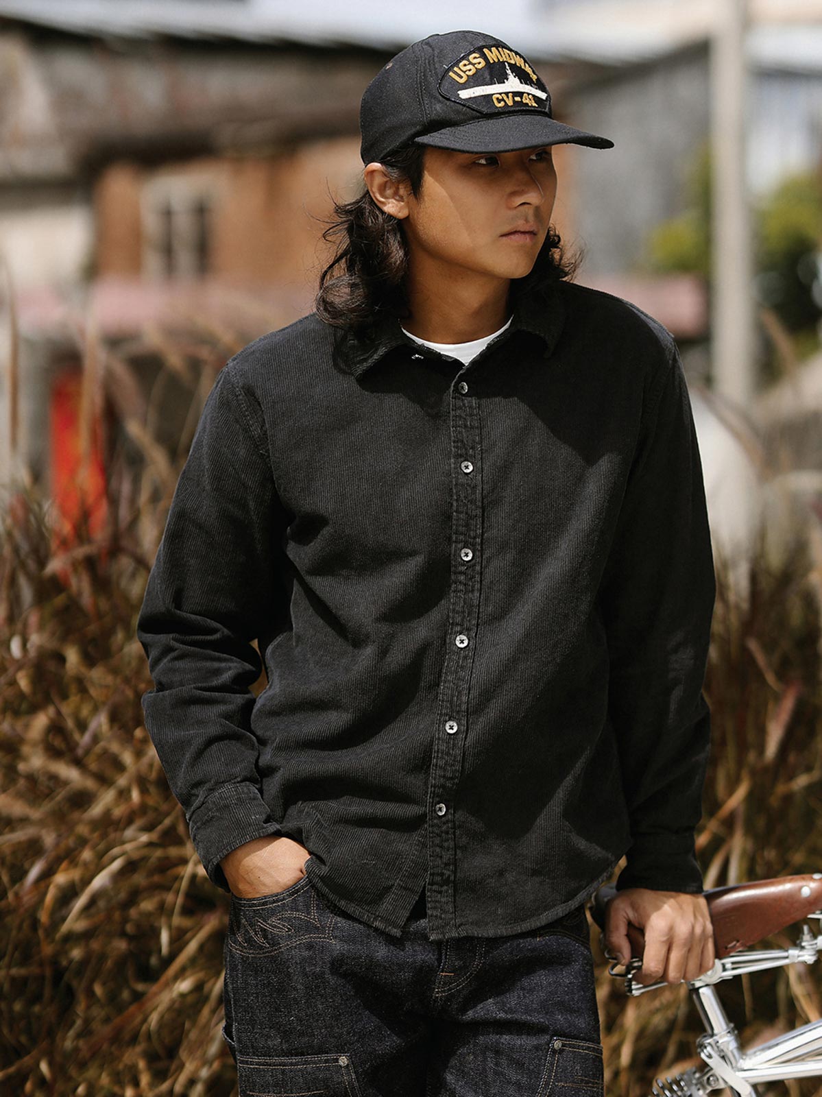 詳細画像: ラウンドヘムとヴィンテージ風ボタンのディテールクローズアップ
モデル画像: コーデュロイシャツを着用したスタイリング例