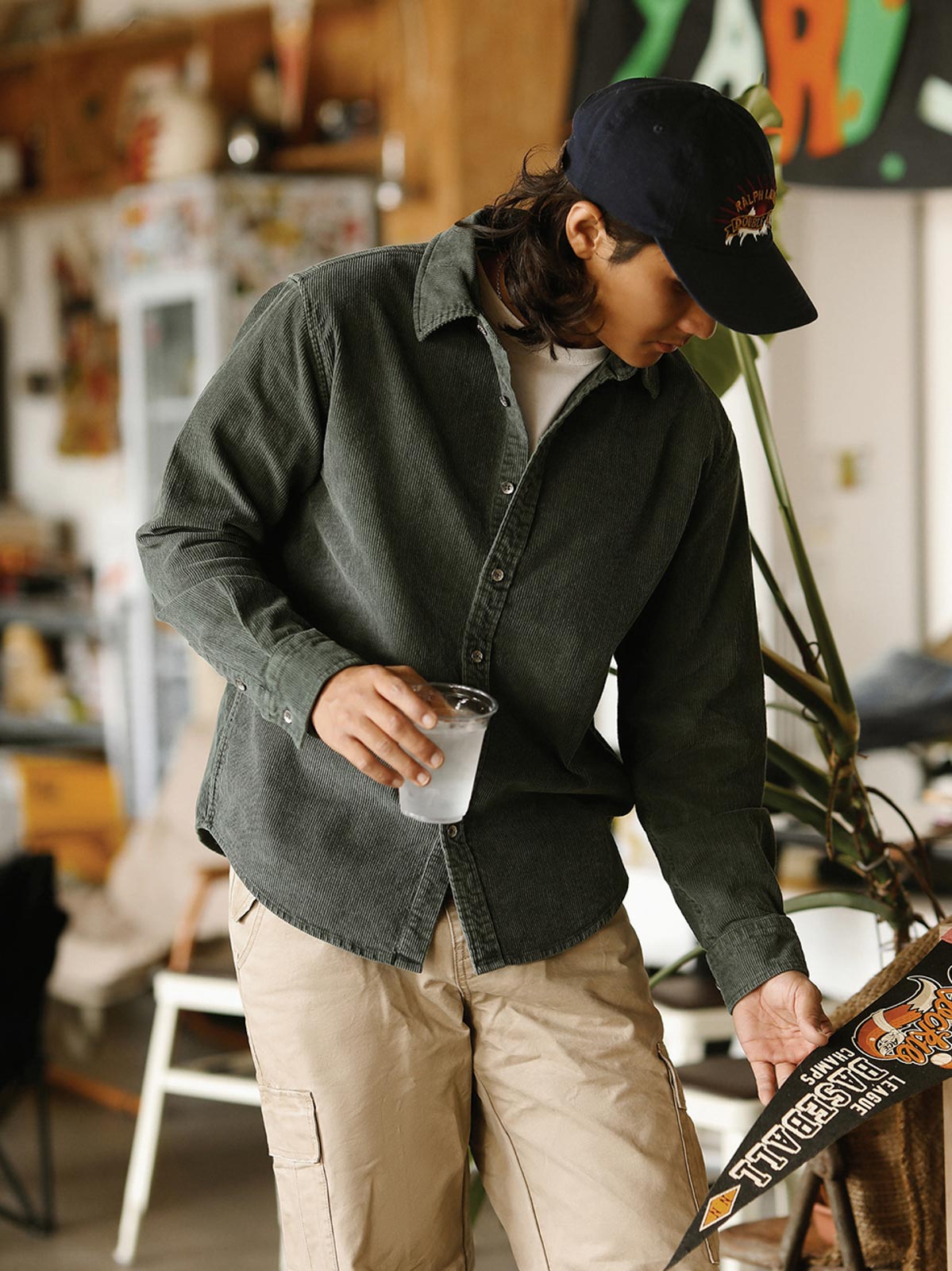 詳細画像: ラウンドヘムとヴィンテージ風ボタンのディテールクローズアップ
モデル画像: コーデュロイシャツを着用したスタイリング例