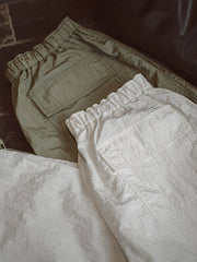 詳細画像: パラシュートパンツの二重防透とドレープデザインのディテール