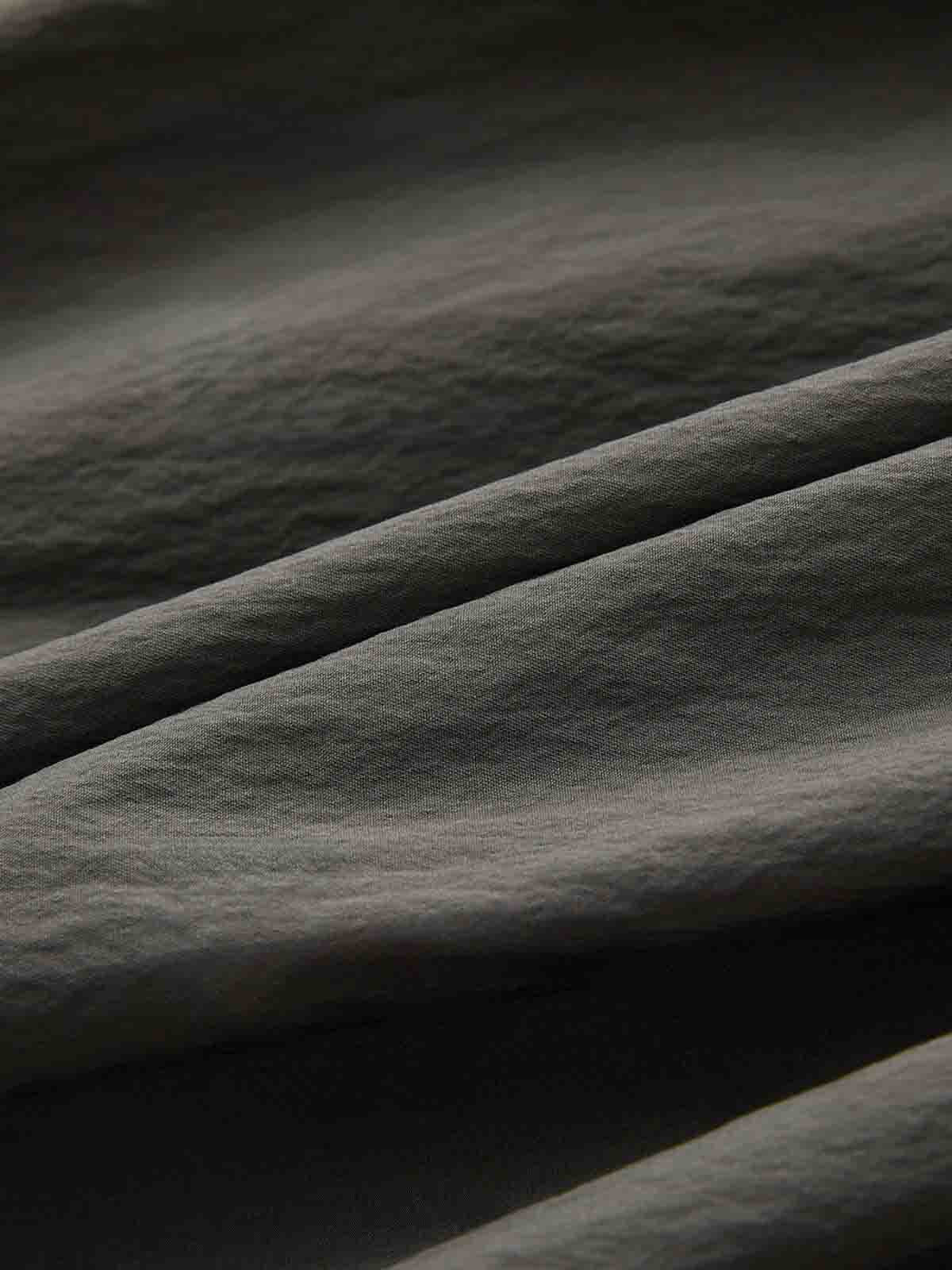 製品画像: アシンメトリーボタンデザインのグレー長袖シャツの正面ビュー
詳細画像: 特別な襟デザインとアシンメトリーボタンのディテール表示