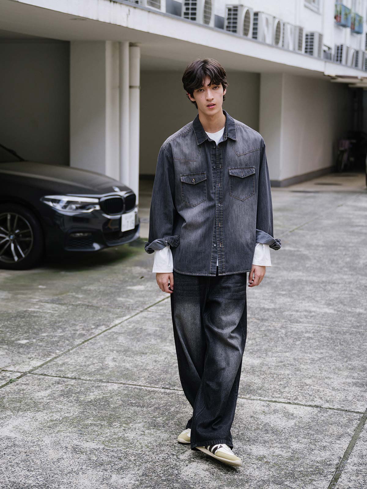 詳細画像: 肩の「V」字型ヨークデザインのディテール表示
モデル画像: モデルが着用したウォッシュドフェードグレーのデニムシャツとカジュアルパンツのスタイリング