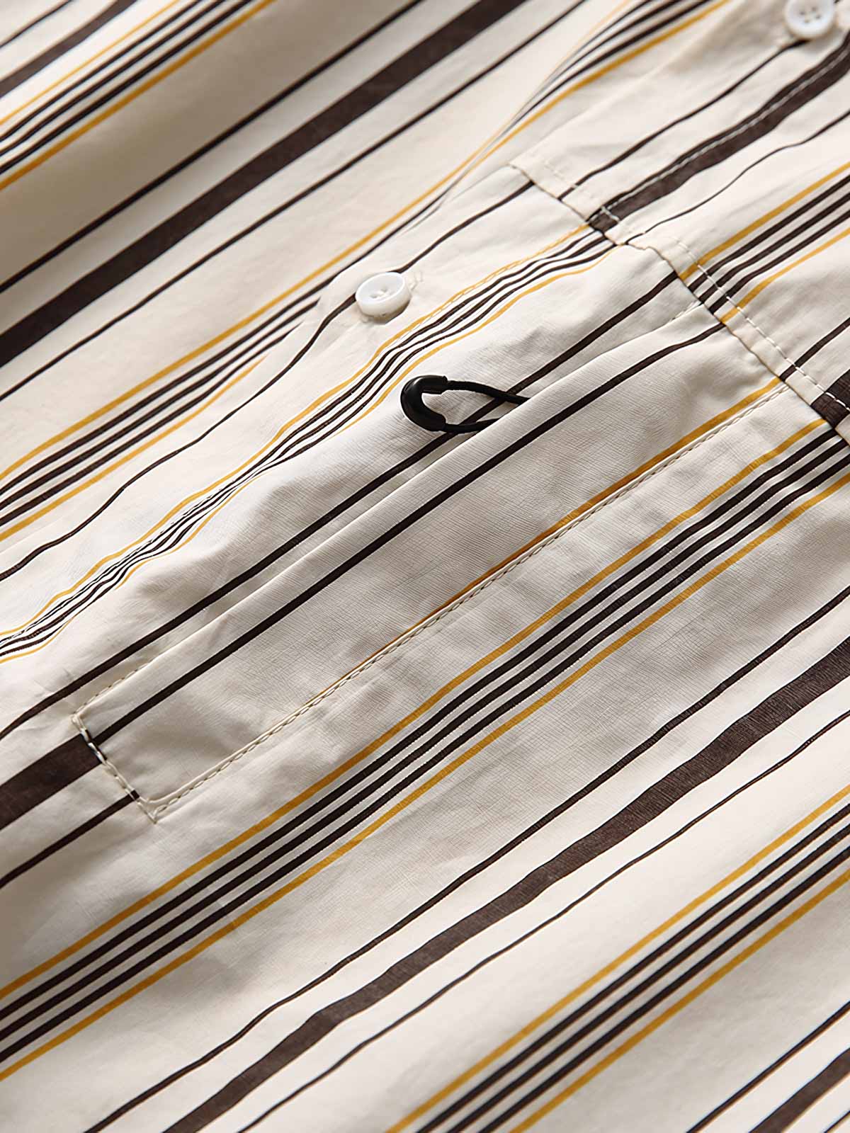 細部にわたるシャツのカラーブロックストライプパターンとフロントポケットのクローズアップ。