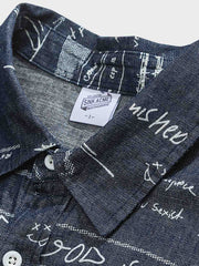 デニム半袖シャツの文字プリントディテール。厳選されたデニム素材と高品質なウォッシュ加工が施され、洗練された外見と耐久性を実現しています。
