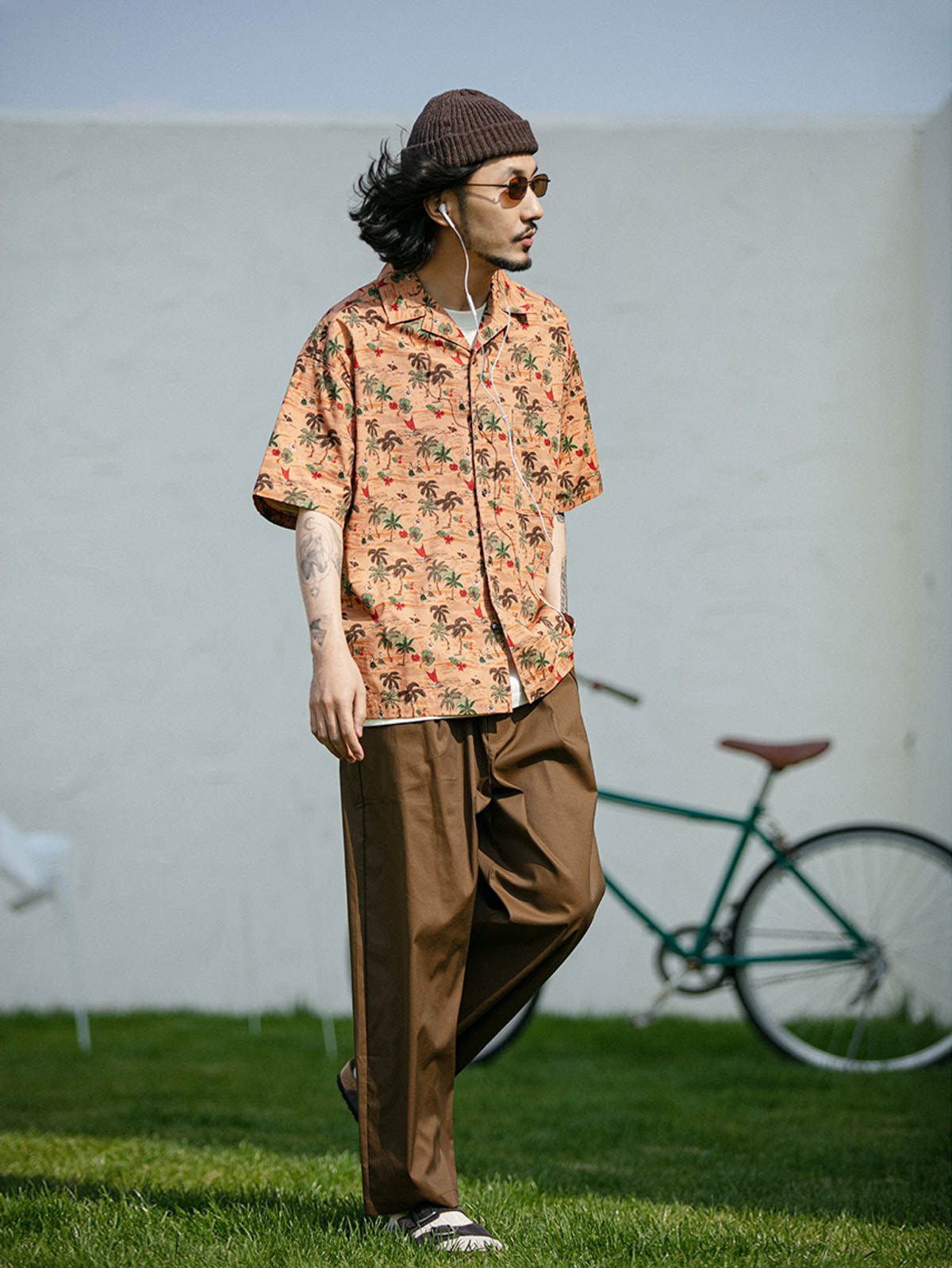 モデルがサンセットビーチプリント半袖シャツを着用し、カジュアルパンツと合わせた様々なアングルを展示