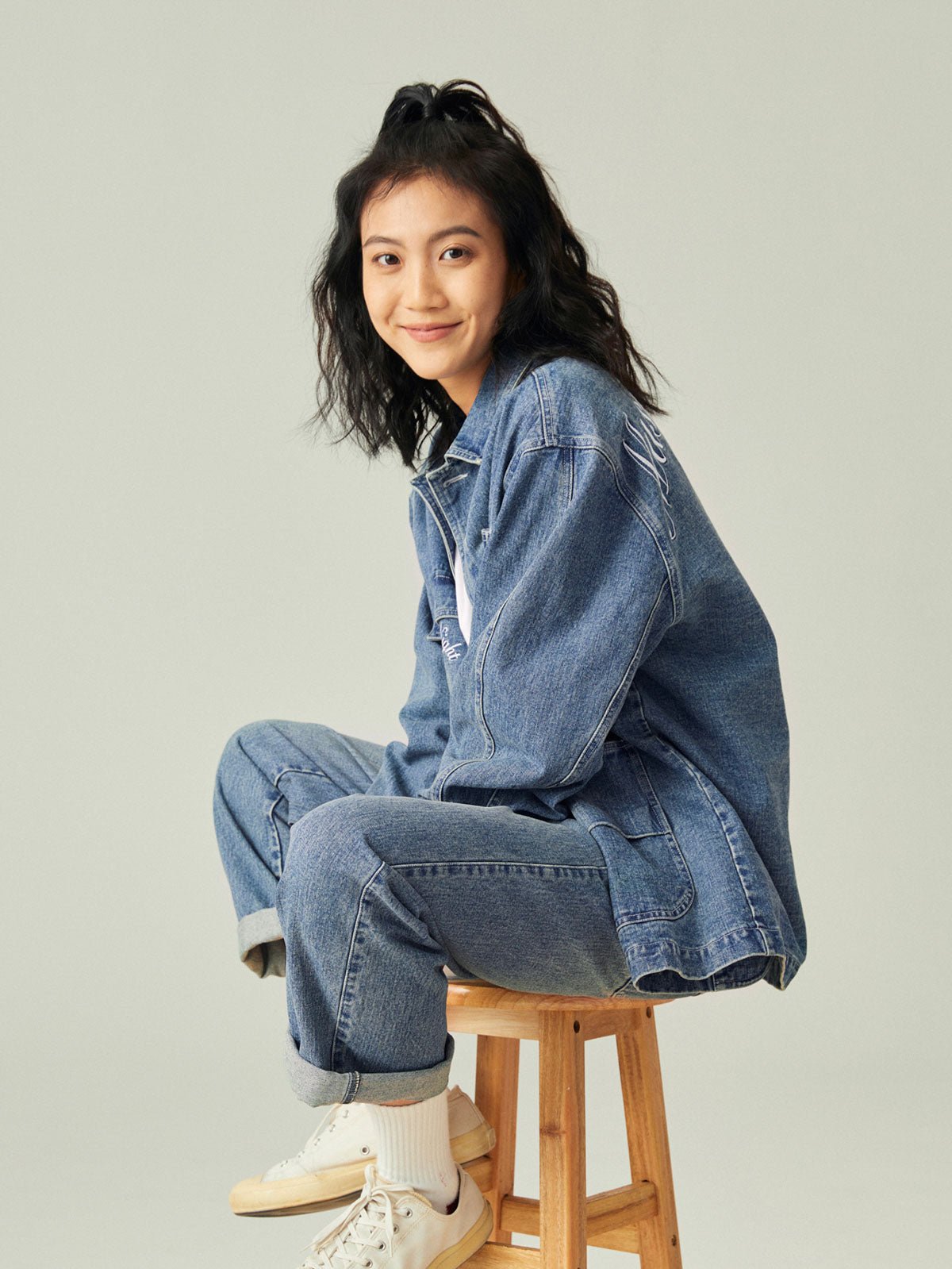 モデル画像: モデルがレトロなワークスタイルのルーズフィットデニムジャケットを着用したスタイル展示