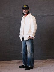 詳細画像: クラシックルーズフィット長袖シャツの高品質な縫製と樹脂ボタンのディテール
モデル画像: ルーズフィットのホワイトシャツを着用したモデルのコーディネート、都会的な通勤スタイル