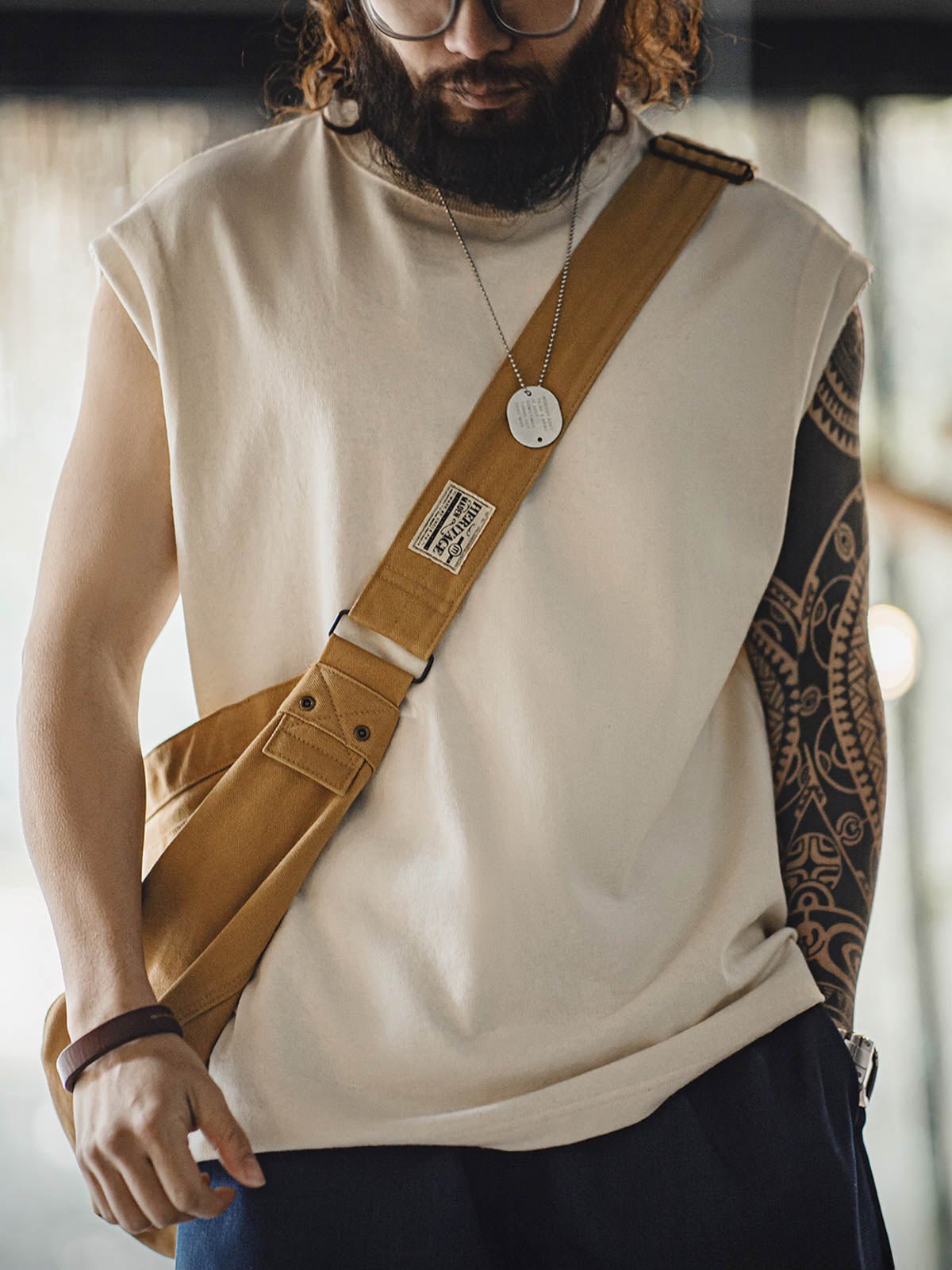 モデルがヘビーウェイトコットンハスクのスリーブレスTシャツを着用し、ルーズフィットのショートパンツとスポーツシューズでスタイリング。リラックスしたカリフォルニアの夏のスタイルを演出しています。