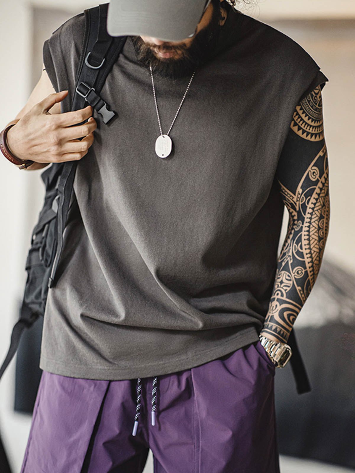 モデルがヘビーウェイトコットンハスクのスリーブレスTシャツを着用し、ルーズフィットのショートパンツとスポーツシューズでスタイリング。リラックスしたカリフォルニアの夏のスタイルを演出しています。