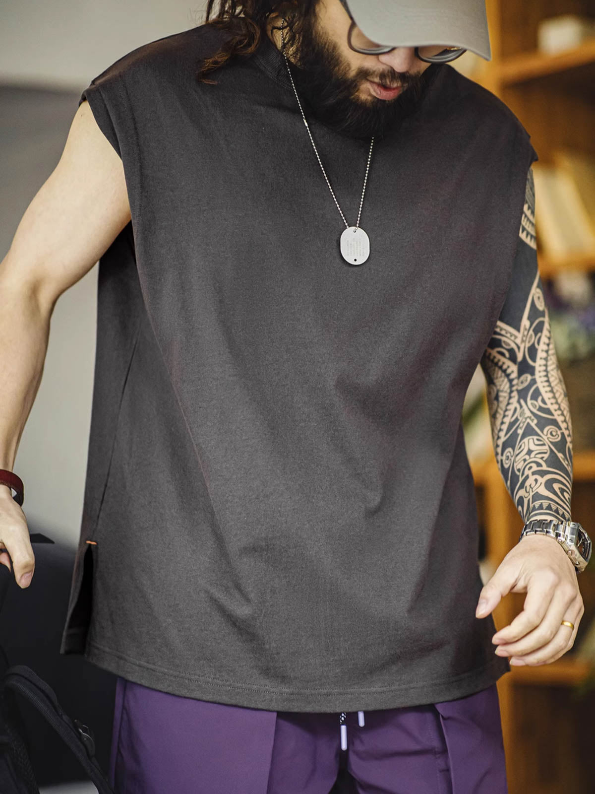 モデルがヘビーウェイトコットンハスクのスリーブレスTシャツを着用し、ルーズフィットのショートパンツとスポーツシューズでスタイリング。リラックスしたカリフォルニアの夏のスタイルを演出しています。