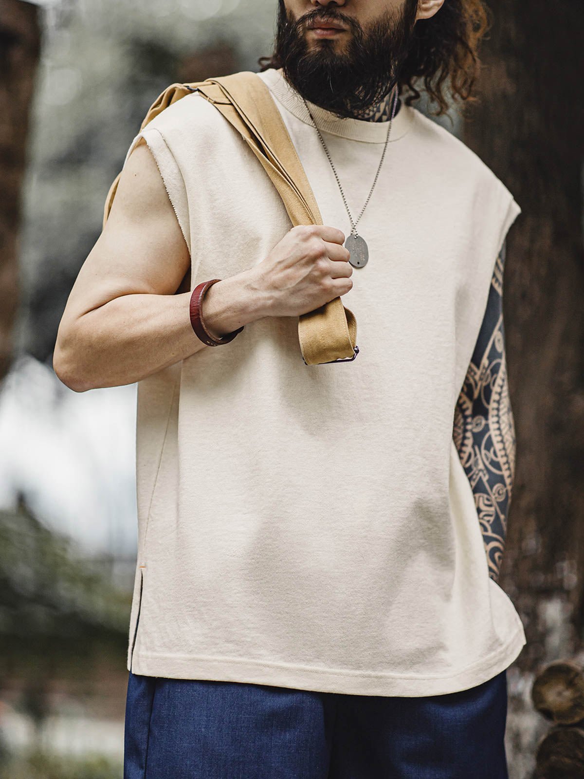 モデルがヘビーウェイトコットンハスクのスリーブレスTシャツを着用し、ルーズフィットのショートパンツとスポーツシューズでスタイリング。リラックスしたカリフォルニアの夏のスタイルを演出しています。