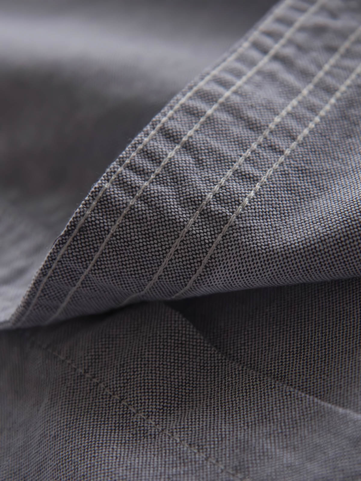 製品画像: パッチワークデザインが施されたオックスフォードシャツの正面全体展示。
詳細画像: パッチワークのディテール、縫い目や素材感を強調したクローズアップ。