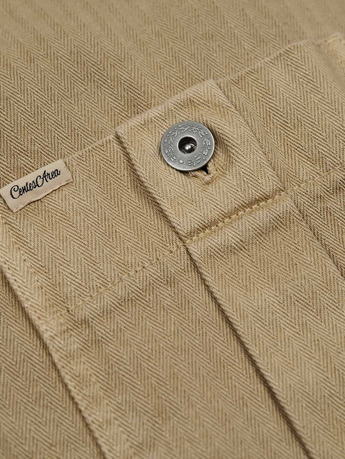 月桂樹ボタンと追加ポケットのクローズアップ、ヘリンボーン生地の詳細が見える。