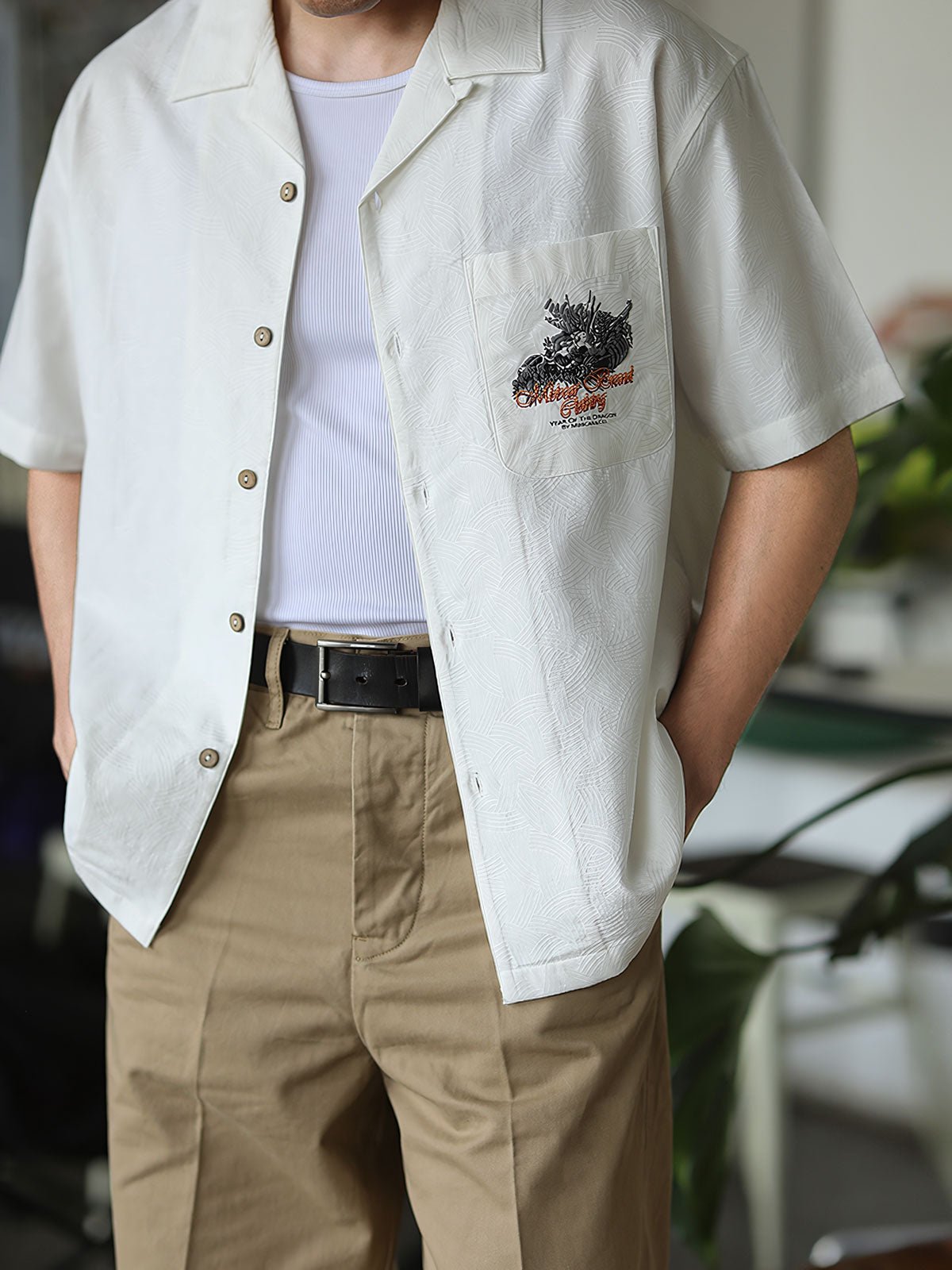 モデルがリネンパンツと合わせて着用するスカルドラゴン刺繍キューバンシャツ。
