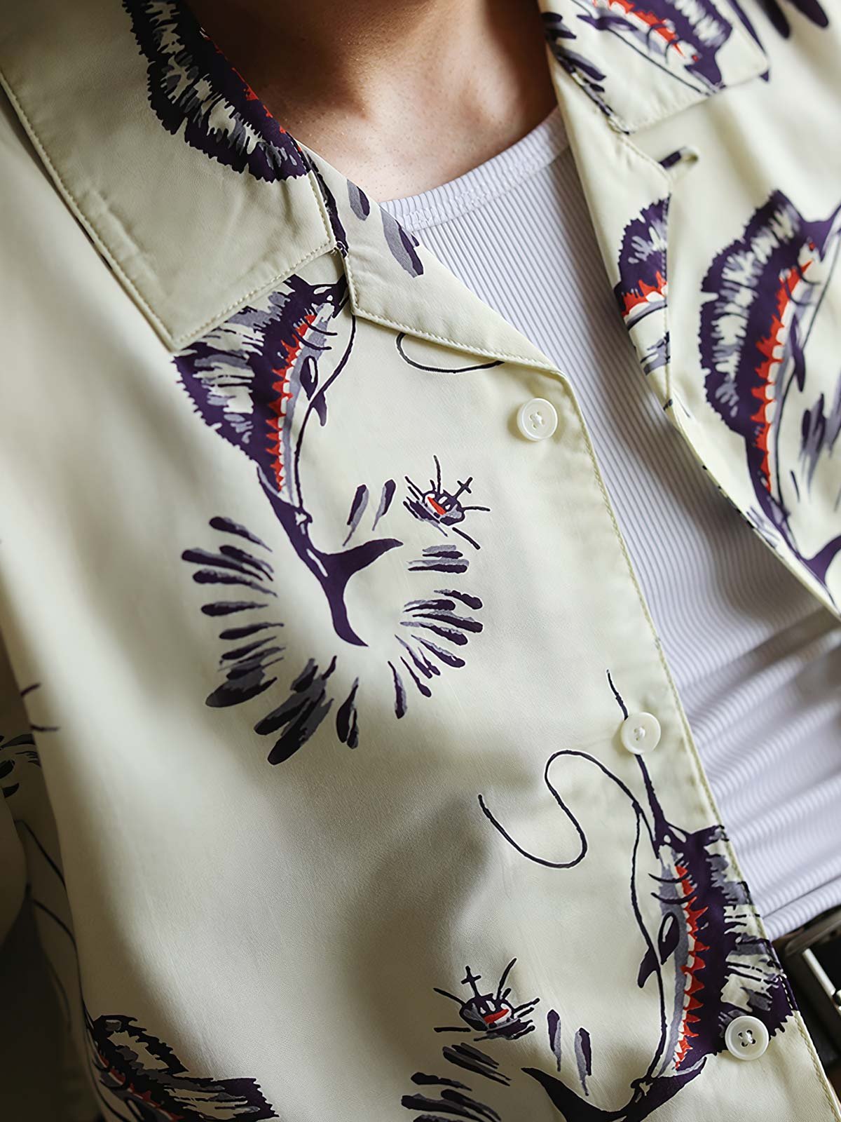 ハワイアンシャツのカジキプリントと高品質な樹脂製ボタンのクローズアップ。