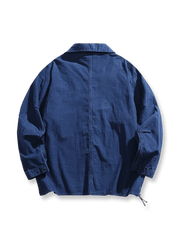 製品画像：ウォッシュデニムのルーズフィットブレザー正面展示。シンプルながら個性的なデザインが特徴。
詳細画像：波模様の裏地と襟元のアウトドア風ボタンディテール。控えめな個性が光るディテール。