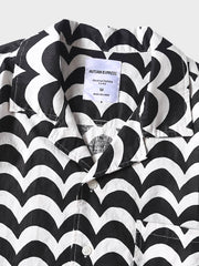 リネンシャツの細かな波状パターンのクローズアップ。黒と白のコントラストが特徴で、精緻な縫製技術を見せる。