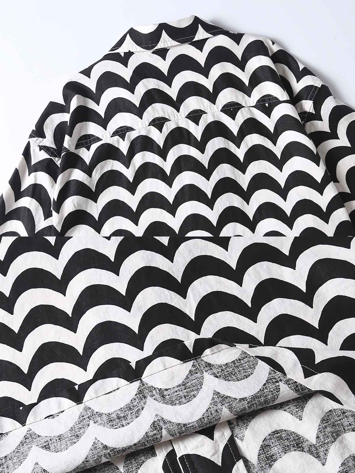 リネンシャツの細かな波状パターンのクローズアップ。黒と白のコントラストが特徴で、精緻な縫製技術を見せる。