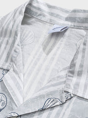 貝殻プリント半袖シャツの精巧なプリントパターンのクローズアップ。繊細な工芸技術と高品質の純綿素材が、快適な着用体験を実現します。