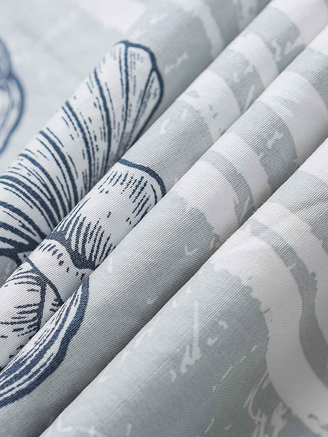 貝殻プリント半袖シャツの精巧なプリントパターンのクローズアップ。繊細な工芸技術と高品質の純綿素材が、快適な着用体験を実現します。