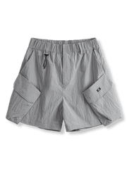 クラシックなチェック柄のアウトドア・ナイロンショーツの正面ビュー。斜めに配置された実用的なマルチポケットと軽量素材が特徴。アクティブな動きをサポートし、どんなアウトドア活動にも適しています。