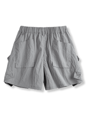 クラシックなチェック柄のアウトドア・ナイロンショーツの正面ビュー。斜めに配置された実用的なマルチポケットと軽量素材が特徴。アクティブな動きをサポートし、どんなアウトドア活動にも適しています。