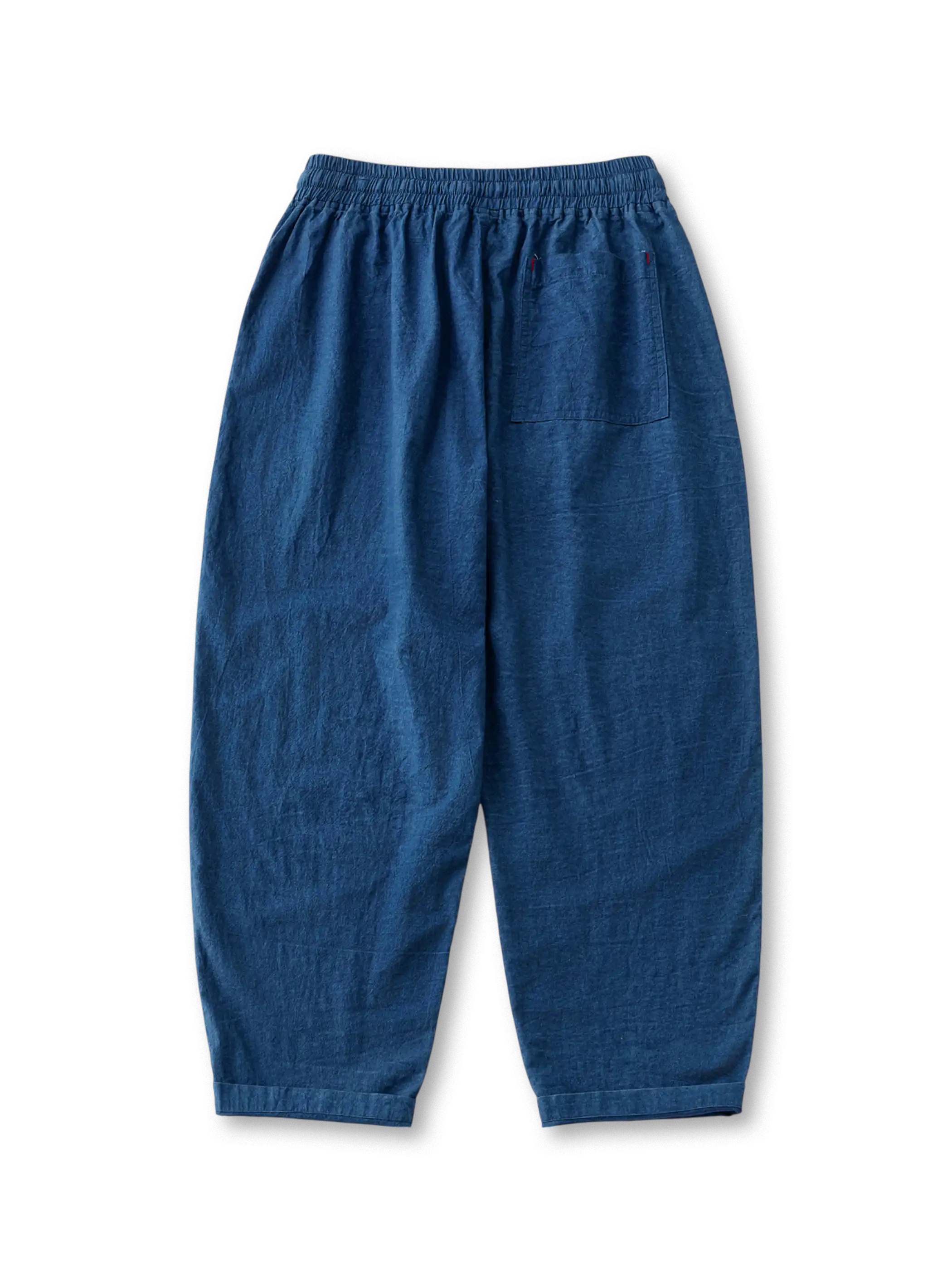 プラントインディゴテーパードパンツの全身ビュー、手作業藍染めの氷裂紋とテーパードシルエットを強調。