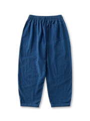 プラントインディゴテーパードパンツの全身ビュー、手作業藍染めの氷裂紋とテーパードシルエットを強調。