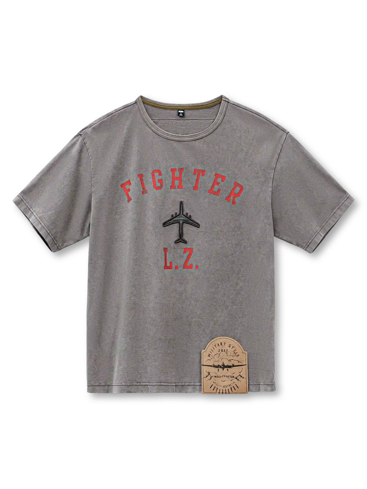 ウォッシュグレーのTシャツ、胸に赤いアーチ文字と機影のプリント、裾の古風なパッチ付き