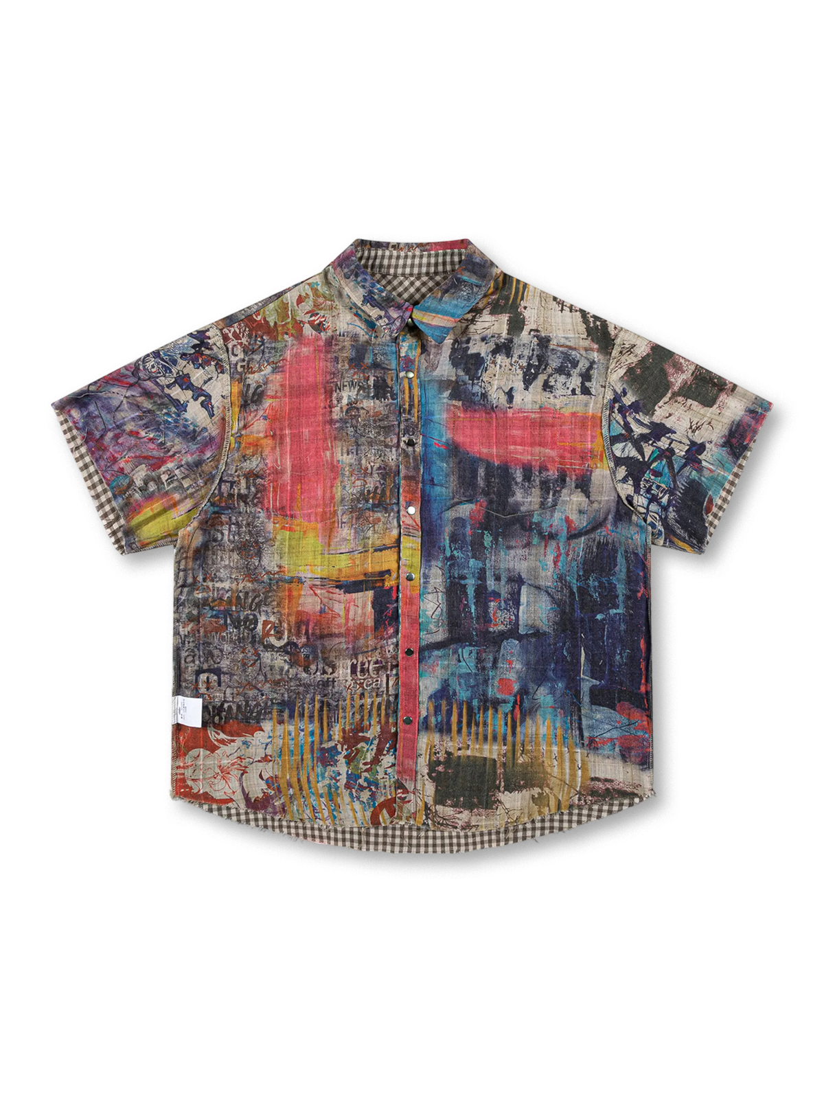 鮮やかなグラフィティプリントとブラウンチェックのリバーシブルデザイン、切りっぱなし裾とダメージ加工が特徴の100%コットンオーバーサイズシャツ。