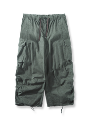 グリッドテクスチャー生地と大型カーゴポケット、シャーリングデザインが特徴のタクティカルアウトドアパラトルーパーパンツの全体像。