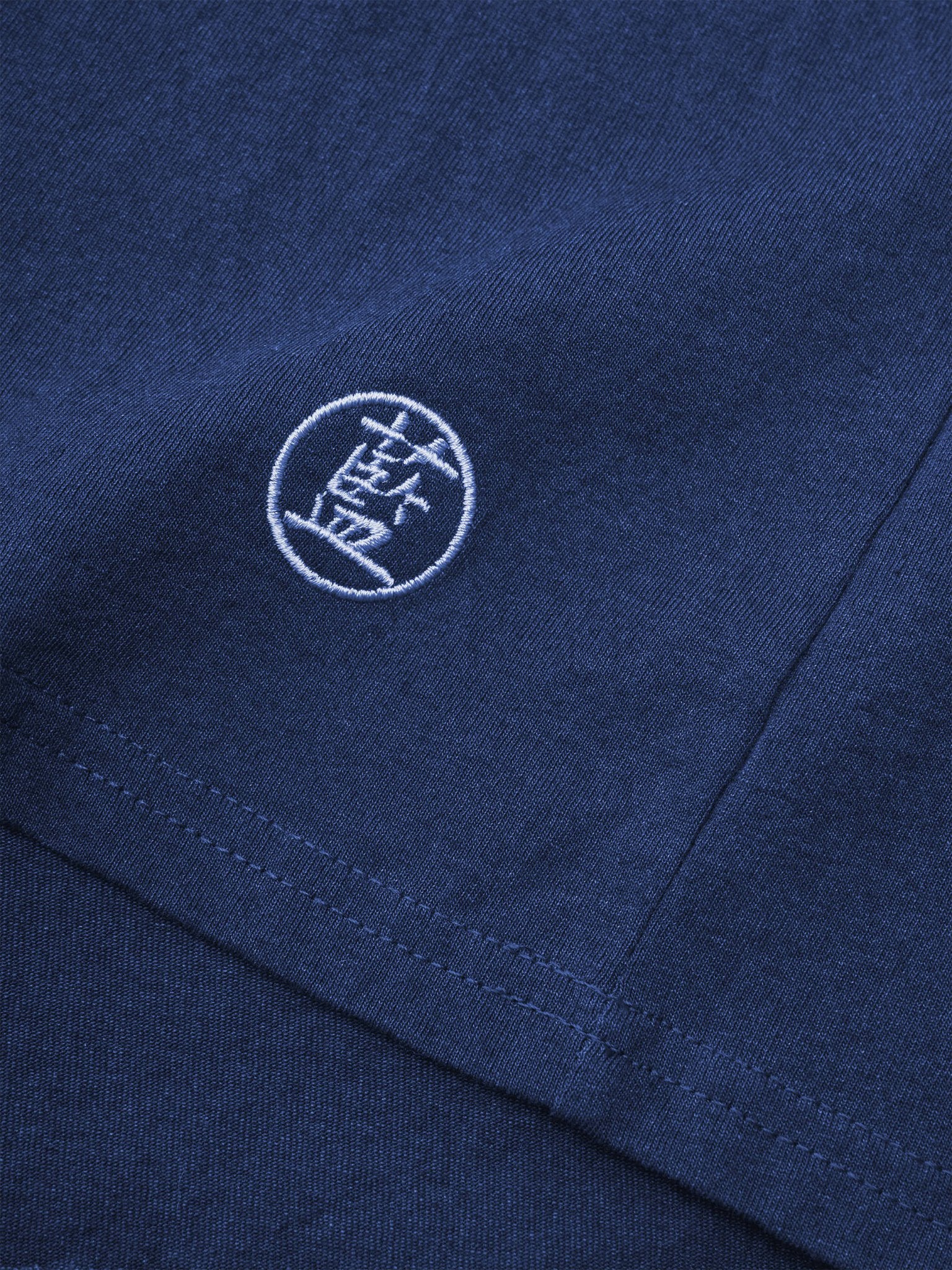 本インディゴTシャツの左下側に施された「藍」刺繍のディテール