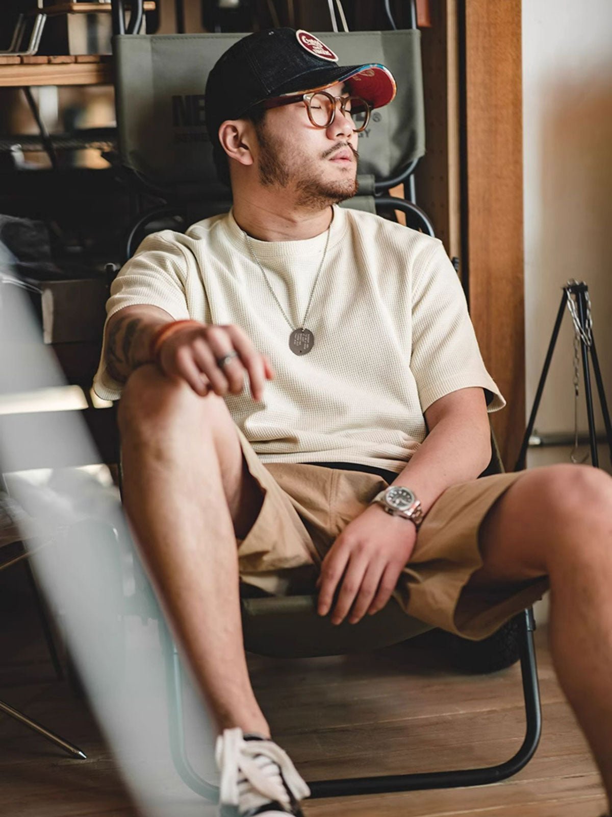 モデルがベージュのワッフル織りニットTシャツを着用。デニムパンツと合わせたカジュアルなスタイリング。