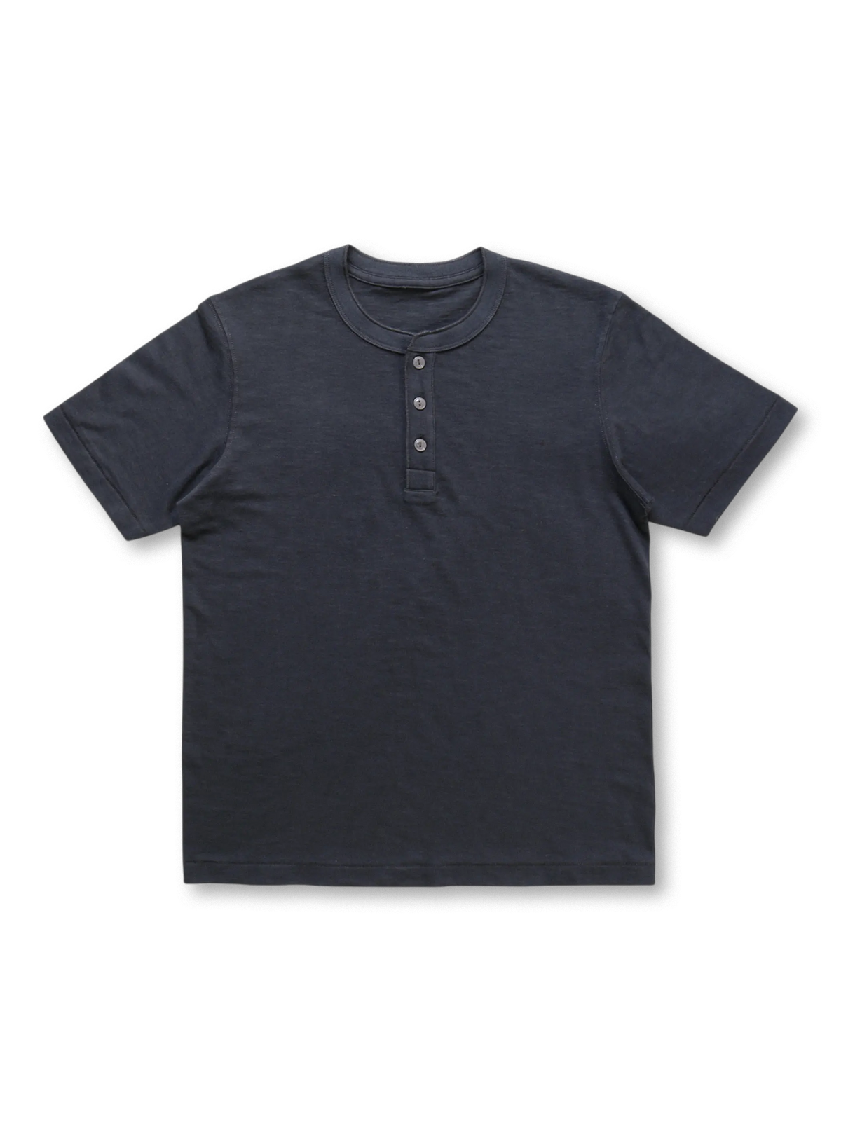  日本製の丸筒織機で編まれた厚みのある生地のヘンリーネックTシャツ。三つの貝ボタンと落ち肩のスタンダードフィットで、リラックス感と耐久性を兼ね備えたデザイン。