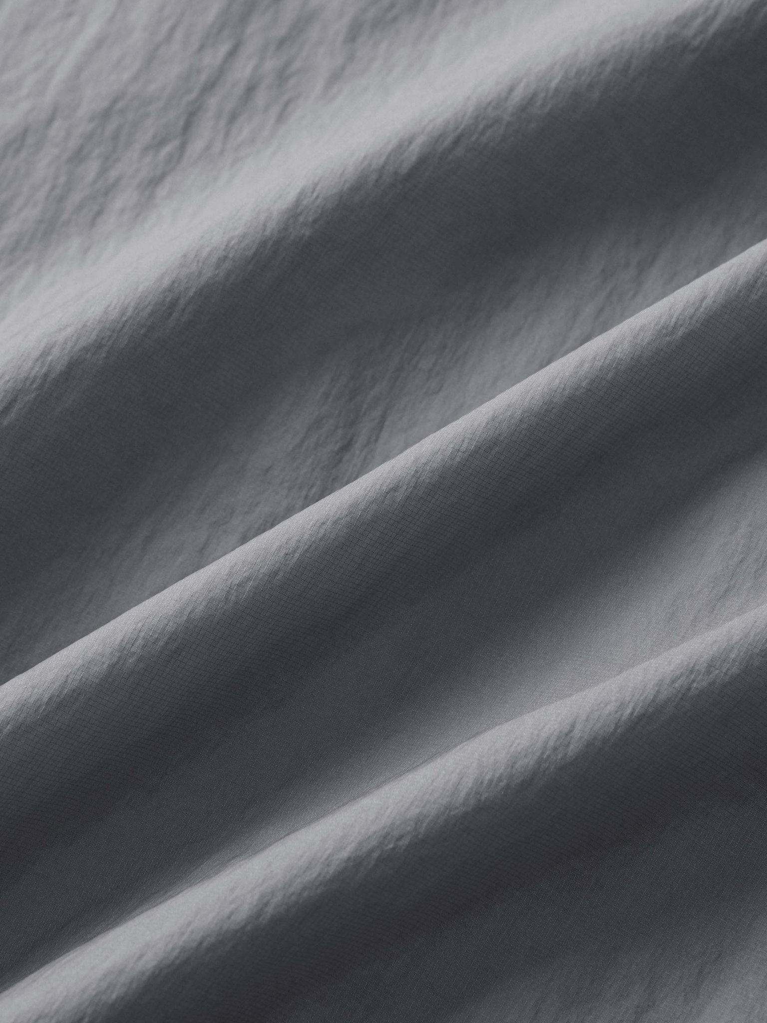 カーブ状のジッパーとサイドポケットのクローズアップ、UPF40+の紫外線対策機能を強調。