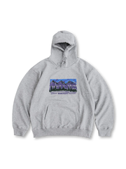 胸元に山の風景アートプリントが施されたヴィンテージアートプリントフーディ。100%綿素材で柔らかく吸汗性が高く、ゆったりフィットとドローストリングフードで快適。前ポケットとレトロカラーのプリントが特徴。