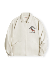 モキンイング刺繍とシルク光仕上げの米杏色コットン生地を使用したヴィンテージコーチジャケット。ルーズフィットと古銅ジッパーが特徴。