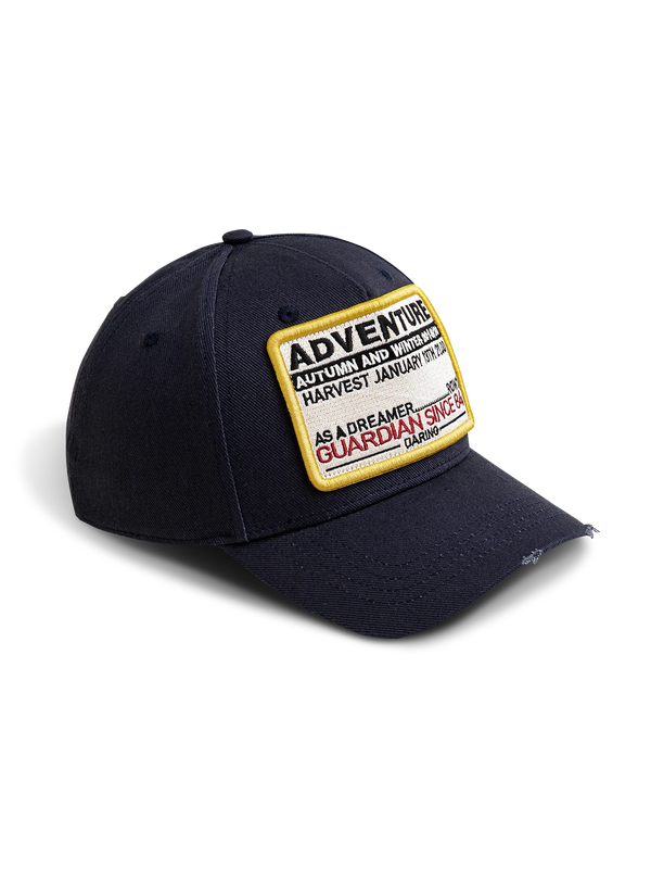 ダメージ加工ツバと「ADVENTURE」レターパッチをあしらったヴィンテージスタイルの6パネルベースボールキャップ。