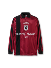 1990年代北米フットボールジャージ風の配色パネルとリブライン、胸元にクレスト刺繍と立体ラバーロゴをあしらった速乾性ポリエステルニットのポロシャツ。