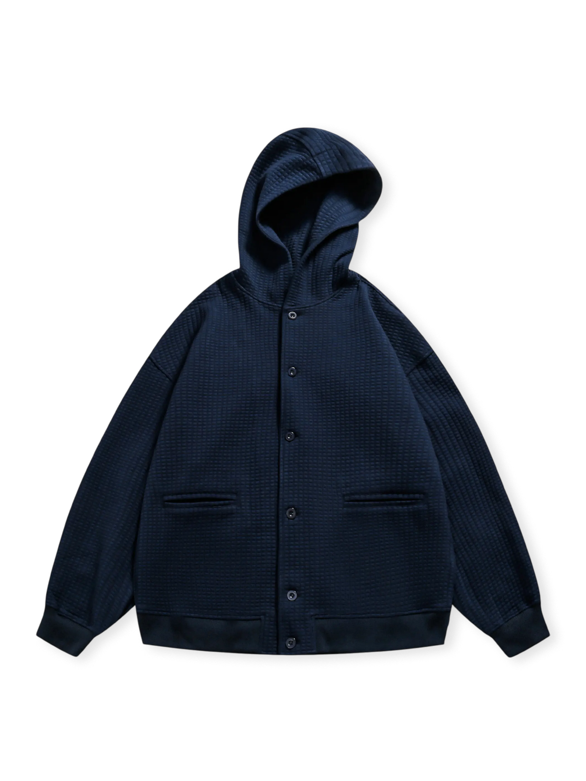 ワッフルチェックの立体織り加工を施したフーデッドジャケット。スナップボタンと収納ポケットが特徴。