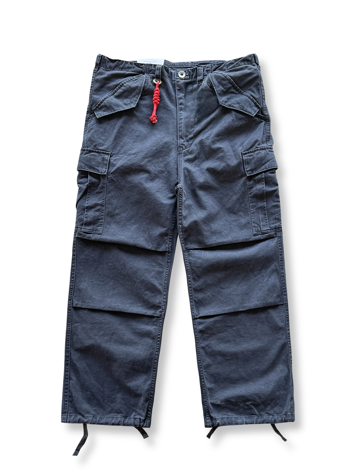 ウォッシュ加工が施された多ポケットワークパンツ。