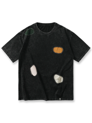 ヴィンテージ感のあるウォッシュ加工と不規則なパッチワークデザインが特徴のコットン製半袖Tシャツ。ルーズフィットで快適な着心地を提供。