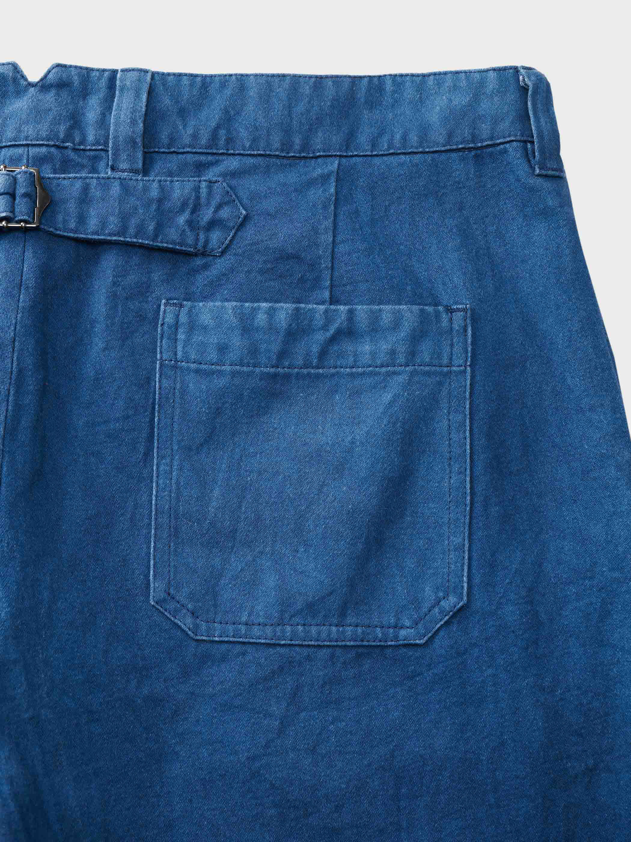 藍染め作業服パンツの後ろのウエストにあるクラシックなバックルバックのD型リングとポケットディテール